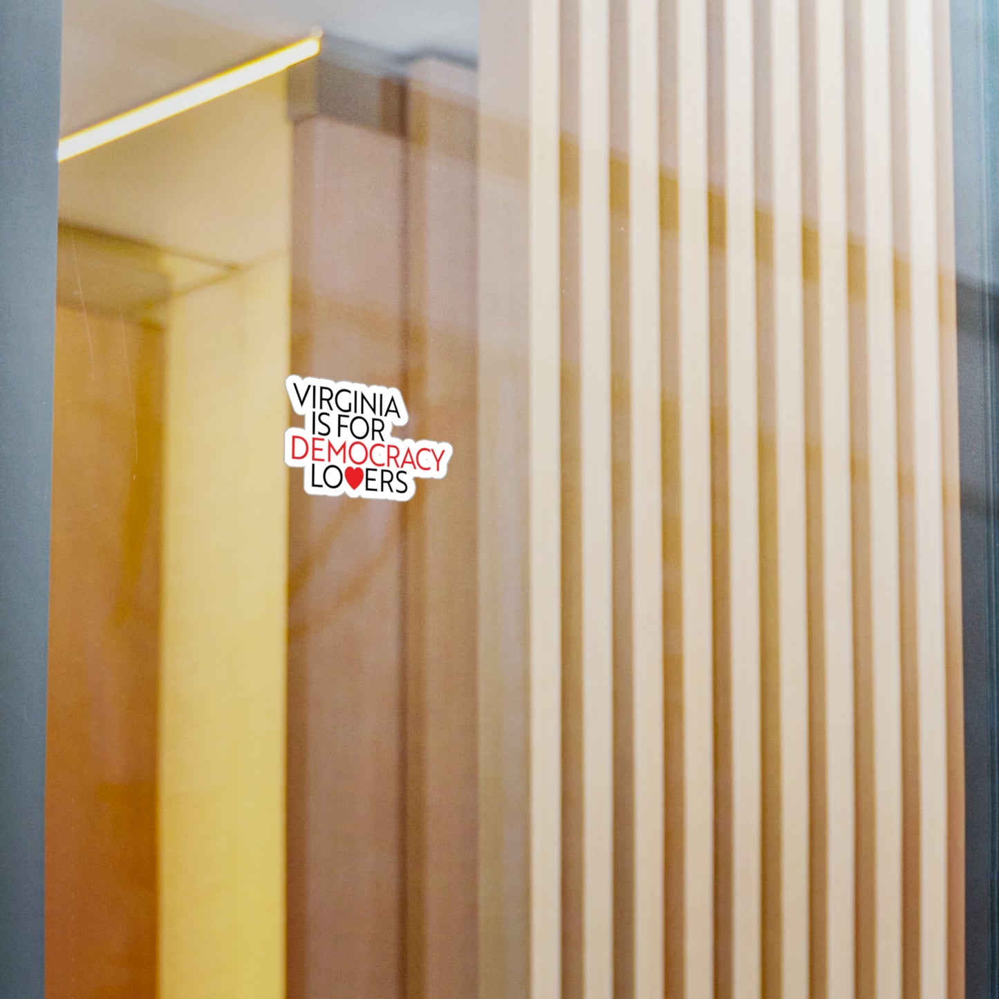 Decorative sticker on a glass surface with text 'Virginia is for democracy lovers'.