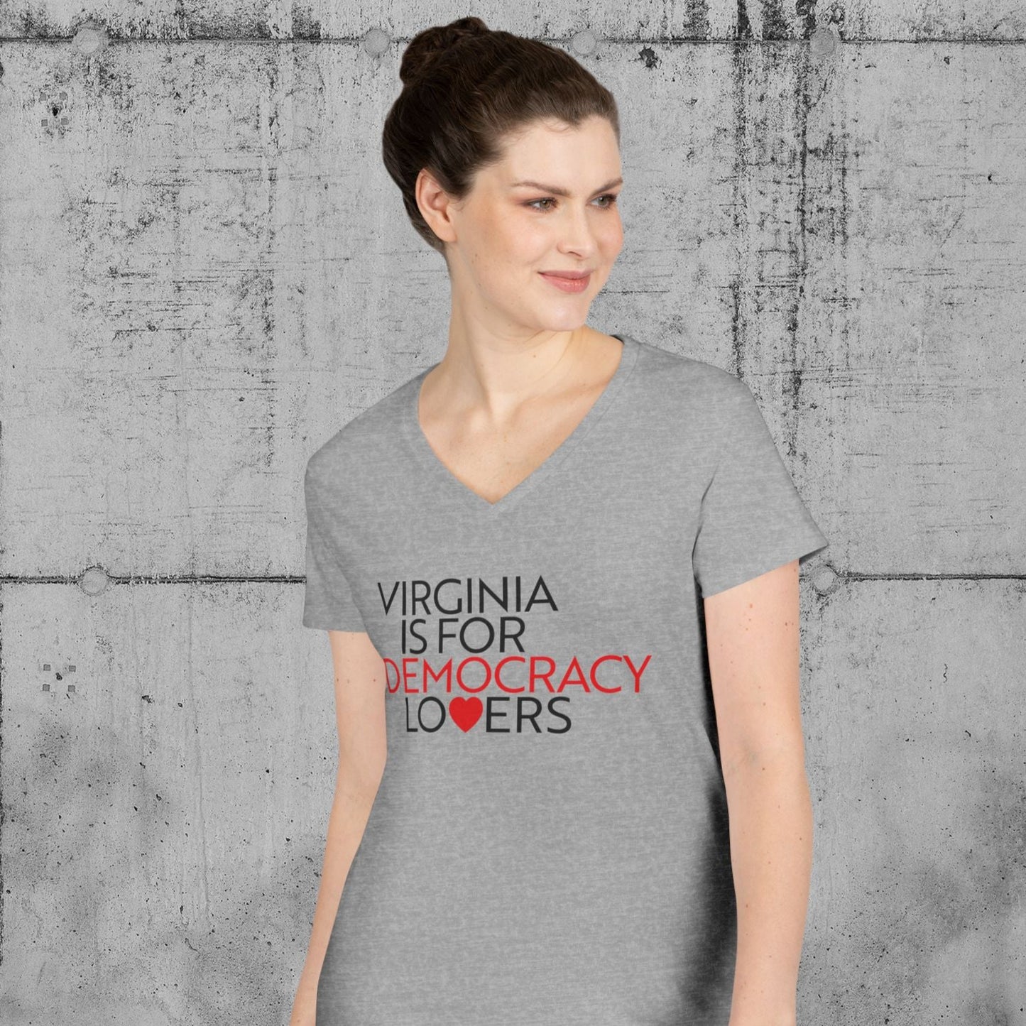 Woman wearing a gray t-shirt with text against a textured gray wall