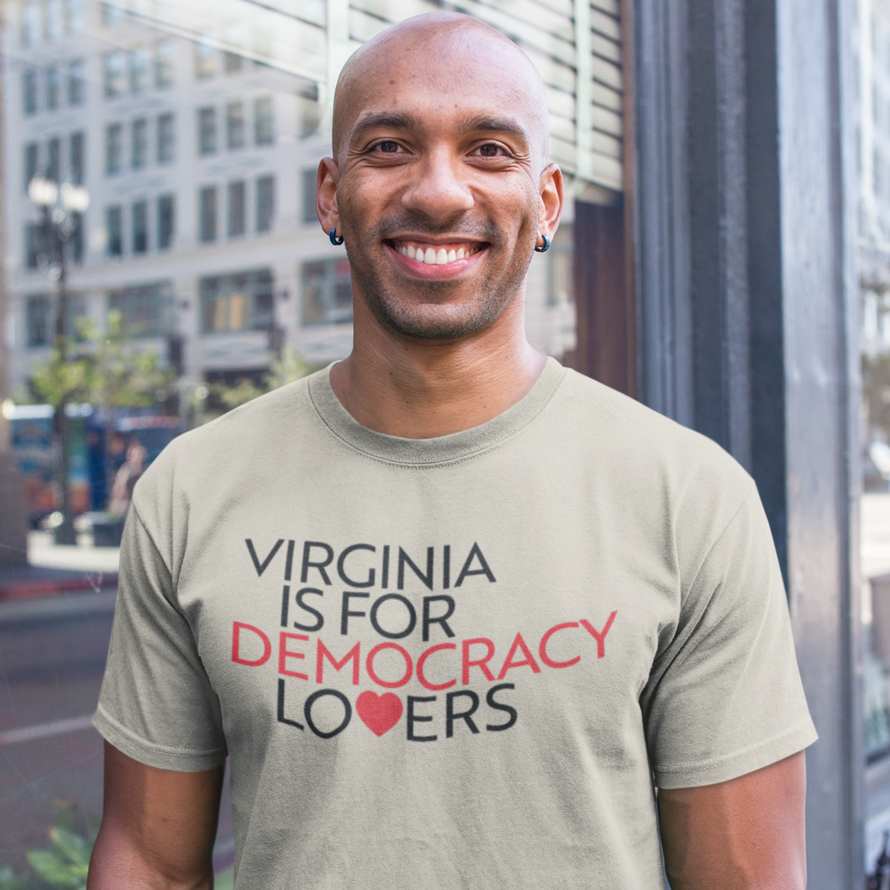 Man wearing a t-shirt with 'Virginia is for Democracy Lovers' text standing in front of a building.