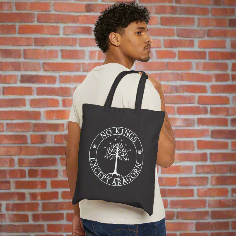 A man carrying a black tote back with the text "No kings except Aragorn" and a graphic f a tree with seven stars above it and two crowns of the king of Gondor.